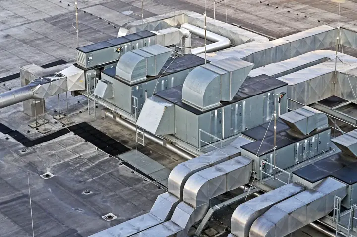 Rooftop air handling units and silver ductwork on a commercial building